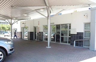 Covered dealership entrance with glazed doors and access control